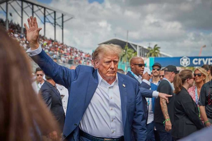 Person in blue suit waving at outdoor event.