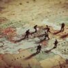Toy soldiers on a world map background.