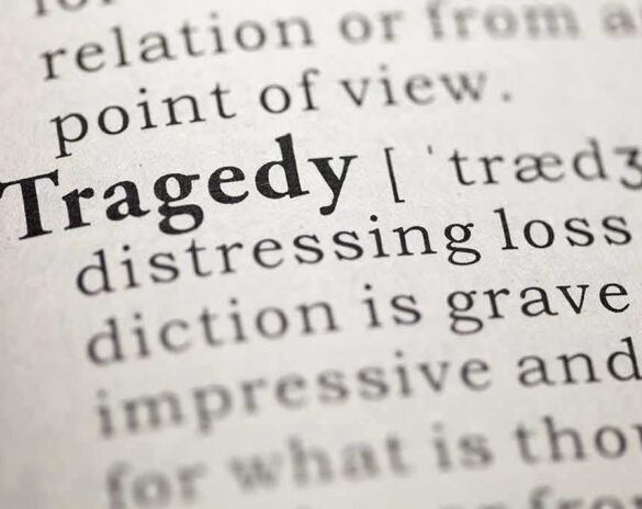 Close-up of the word 'Tragedy' in a dictionary with its definition