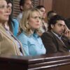 A group of jury members sitting in a courtroom with serious expressions
