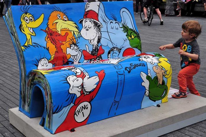 A colorful bench featuring Dr. Seuss characters with a child playing nearby