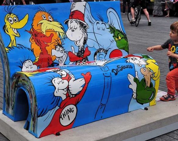 A colorful bench featuring Dr. Seuss characters with a child playing nearby