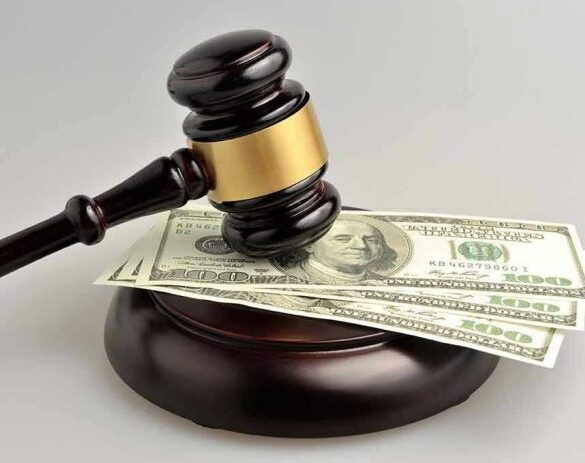 Gavel resting on hundred-dollar bills.