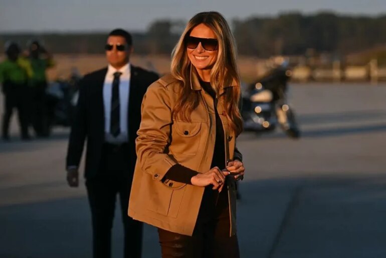US First Lady Melania Trump smiles as she boards the plane to depart from Albert J. Ellis Airport in Jacksonville, North Carolina, November 19, 2025. First Lady Melania Trump and Second Lady Usha Vance are returning to Washington after visiting military families at Marine Corps Air Station New River in Jacksonville, North Carolina. (Photo by SAUL LOEB / AFP) (Photo by SAUL LOEB/AFP via Getty Images)