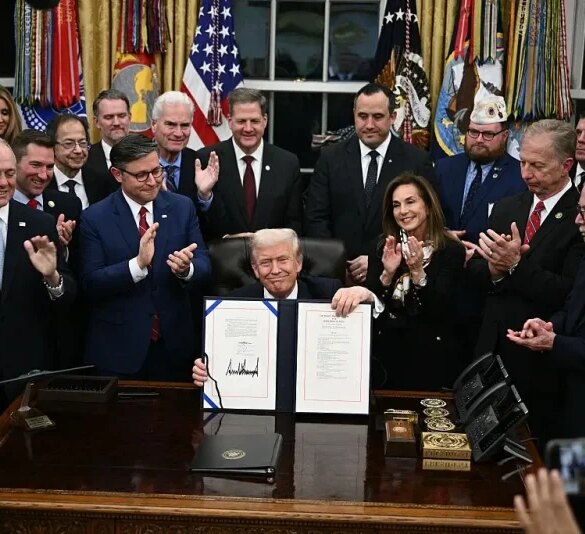US President Donald Trump (C) shows the signed bill package to re-open the federal government in the Oval Office of the White House in Washington, DC, on November 12, 2025. Congress on Wednesday ended the longest government shutdown in US history, 43 days that paralyzed Washington and left hundreds of thousands of workers unpaid while Republicans and Democrats played a high-stakes blame game. The Republican-led House of Representatives voted largely along party lines to approve a Senate-passed package that will reopen federal departments and agencies, as many Democrats fume over what they see as a capitulation by party leaders. (Photo by Brendan SMIALOWSKI / AFP) (Photo by BRENDAN SMIALOWSKI/AFP via Getty Images)