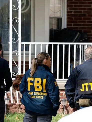 Members of the FBI Joint Terrorism Task Force stand in the front yard as they search a home in Dearborn, Michigan, on October 31, 2025. FBI Director Kash Patel said Friday that the agency had thwarted a "potential terrorist attack" planned in the northern state of Michigan over Halloween weekend. Patel said the FBI arrested multiple subjects. (Photo by JEFF KOWALSKY / AFP) (Photo by JEFF KOWALSKY/AFP via Getty Images)