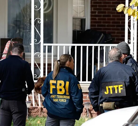 Members of the FBI Joint Terrorism Task Force stand in the front yard as they search a home in Dearborn, Michigan, on October 31, 2025. FBI Director Kash Patel said Friday that the agency had thwarted a "potential terrorist attack" planned in the northern state of Michigan over Halloween weekend. Patel said the FBI arrested multiple subjects. (Photo by JEFF KOWALSKY / AFP) (Photo by JEFF KOWALSKY/AFP via Getty Images)