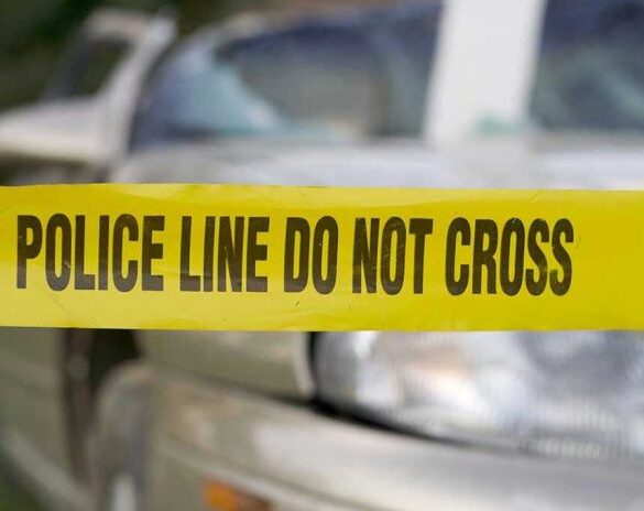 Yellow police tape in front of a car.