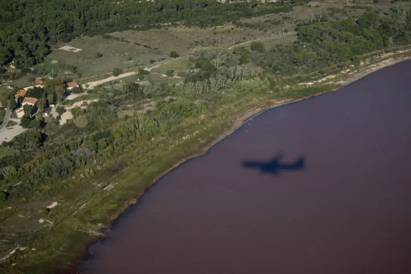 This photograph shows an aerial view of a shadow of a plane flying over the pink Lavalduc Lake in Istres, southeastern France, on October 4, 2024. (Photo by CLEMENT MAHOUDEAU / AFP) (Photo by CLEMENT MAHOUDEAU/AFP via Getty Images)