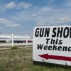 Sign advertising a gun show happening this weekend with an arrow pointing left