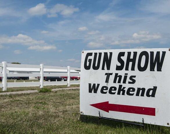 Sign advertising a gun show happening this weekend with an arrow pointing left