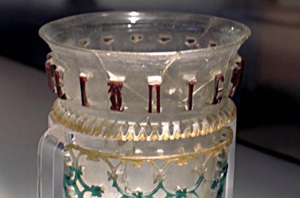 Glass openwork vessel from 300–350 AD with inscription and symbol.