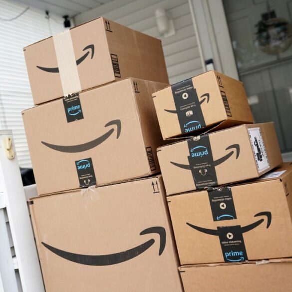 A pile of Amazon Prime boxes stacked on a porch.