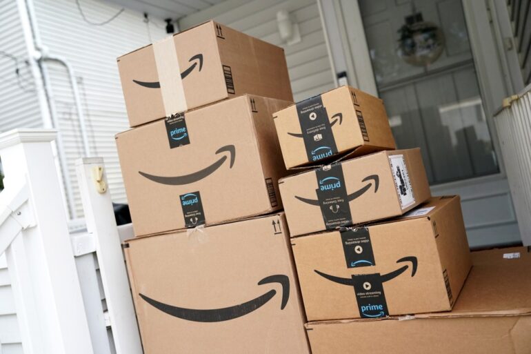 A pile of Amazon Prime boxes stacked on a porch.