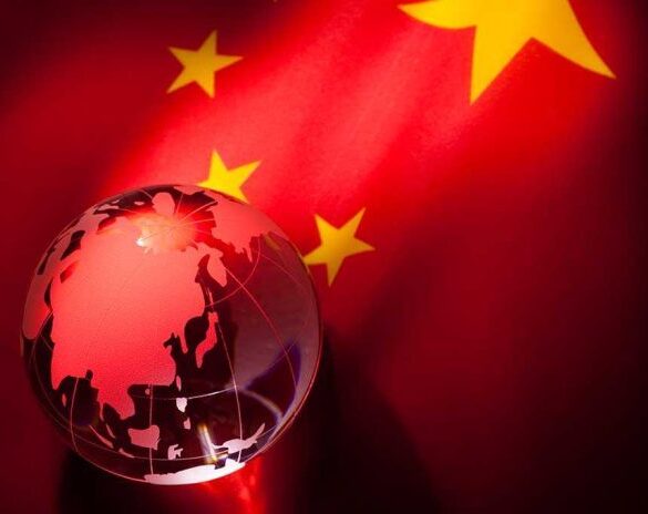 A globe illuminated against the backdrop of the Chinese flag