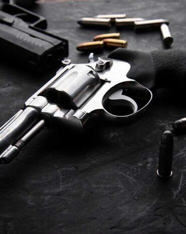 Revolvers and bullets on a dark surface.