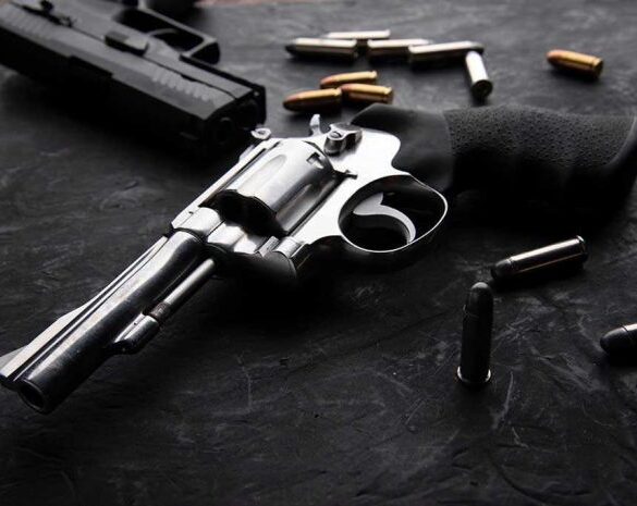 Revolvers and bullets on a dark surface.