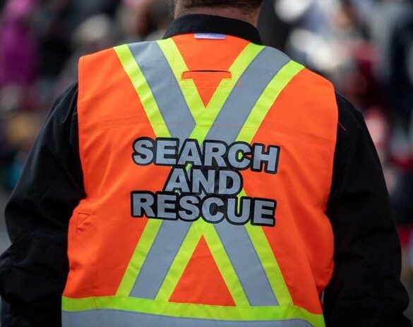 Person wearing a bright orange search and rescue vest
