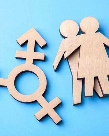 Wooden transgender symbol and couple figures on blue background.