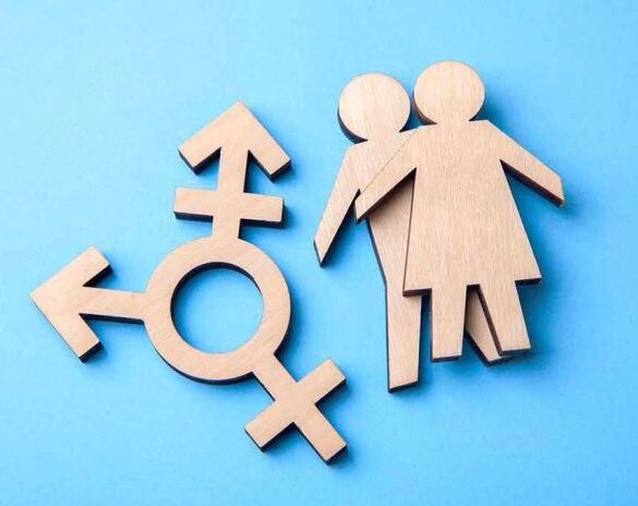 Wooden transgender symbol and couple figures on blue background.