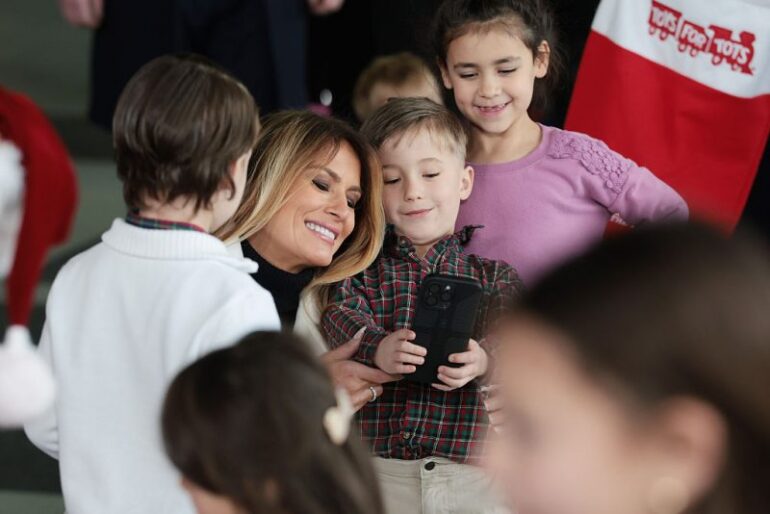 QUANTICO, VIRGINIA - DECEMBER 08: First lady Melania Trump takes photos with children of service members during a Toys for Tots Charity Drive at Marine Corps Base Quantico on December 08, 2025 in Quantico, Virginia. Mrs. Trump delivered remarks to military families and helped children make Christmas cards and sort toys. (Photo by Anna Moneymaker/Getty Images)