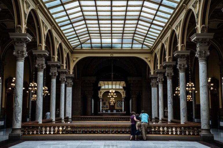 INDIANAPOLIS, IN - JULY 25: A family watches protesters from the top floor of the Indiana State Capitol building on July 25, 2022 in Indianapolis, Indiana. Activists are gathering during a special session of the Indiana state Senate concerning abortion access in the state. (Photo by Jon Cherry/Getty Images)