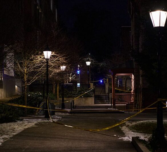 Police crime scene tape is seen near the Barus & Holley engineering building at Brown University, the site of a December 13 mass shooting in Providence, Rhode Island, on December 15, 2025. A gunman remained at large after a weekend mass shooting at elite Brown University left two dead and nine wounded, with US authorities releasing new footage of a masked "person of interest" captured on surveillance cameras. The shooting took place December 13 in a building where exams were underway on the Ivy League campus in Providence, Rhode Island when a man with a rifle burst in and opened fire before fleeing. (Photo by Bing Guan / AFP via Getty Images)