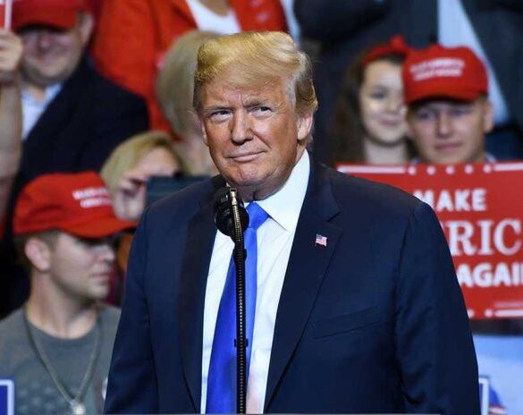 Person at a rally with Make America Great Again signs.