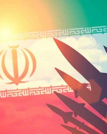 Silhouettes of missiles over Irans flag graphic.