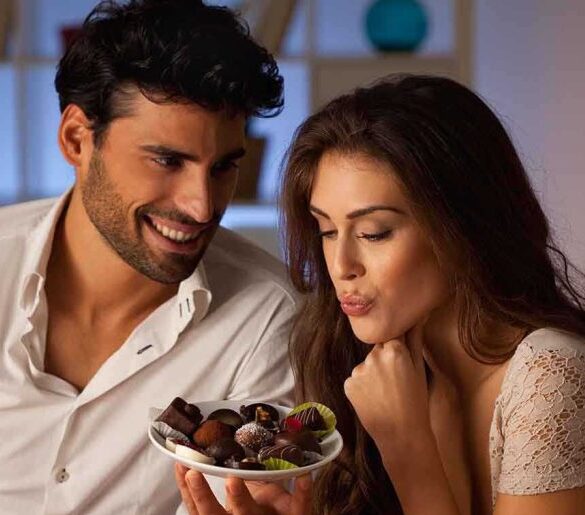 A couple sharing a plate of desserts in a cozy indoor setting