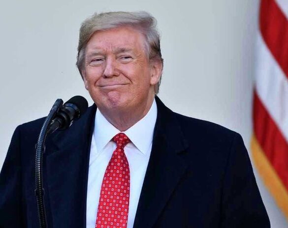 Man in suit and tie speaking at podium.