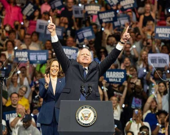 People cheering at a political rally, man raising arms.