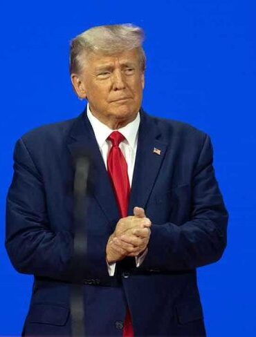 Man in a suit with a blue background.