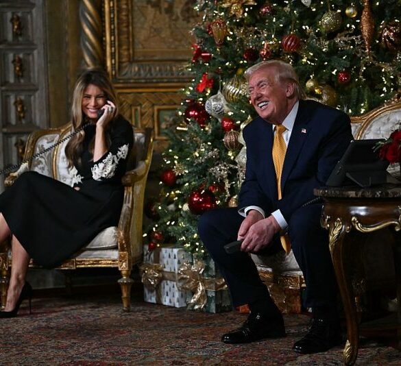 US President Donald Trump and first lady Melania Trump participate in NORAD Santa tracker phone calls, on Christmas Eve, from the Mar-a-lago club in Palm Beach, Florida, on December 24, 2025. (Photo by ANDREW CABALLERO-REYNOLDS / AFP via Getty Images)