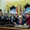 WASHINGTON, DC - DECEMBER 12: U.S. President Donald Trump puts on a hat given to him by the 1980 U.S. Olympic men’s ice hockey team as Trump honors the team in the Oval Office of the White House on December 13, 2025 in Washington, DC. Trump honored the ‘Miracle on Ice’ team, who defeated the Soviet Union and went on to win the 1980 Gold medal in Ice Hockey, by signing a bill to award the players congressional gold medals. (Photo by Anna Moneymaker/Getty Images)