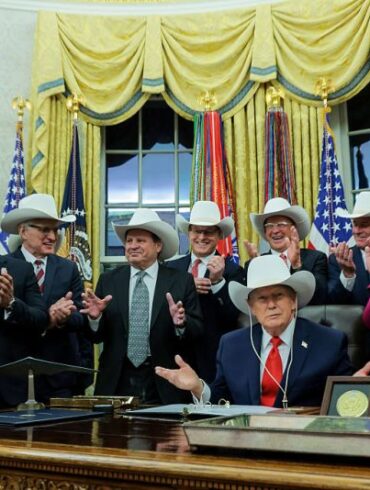 WASHINGTON, DC - DECEMBER 12: U.S. President Donald Trump puts on a hat given to him by the 1980 U.S. Olympic men’s ice hockey team as Trump honors the team in the Oval Office of the White House on December 13, 2025 in Washington, DC. Trump honored the ‘Miracle on Ice’ team, who defeated the Soviet Union and went on to win the 1980 Gold medal in Ice Hockey, by signing a bill to award the players congressional gold medals. (Photo by Anna Moneymaker/Getty Images)