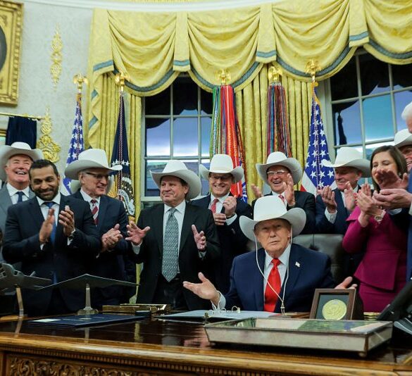 WASHINGTON, DC - DECEMBER 12: U.S. President Donald Trump puts on a hat given to him by the 1980 U.S. Olympic men’s ice hockey team as Trump honors the team in the Oval Office of the White House on December 13, 2025 in Washington, DC. Trump honored the ‘Miracle on Ice’ team, who defeated the Soviet Union and went on to win the 1980 Gold medal in Ice Hockey, by signing a bill to award the players congressional gold medals. (Photo by Anna Moneymaker/Getty Images)