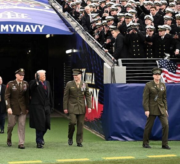 US President Donald Trump waves as he arrives on the field before the college football game between the US Army and Navy at the M&T Bank Stadium in Baltimore, Maryland, on December 13, 2025. (Photo by Alex WROBLEWSKI / AFP via Getty Images)