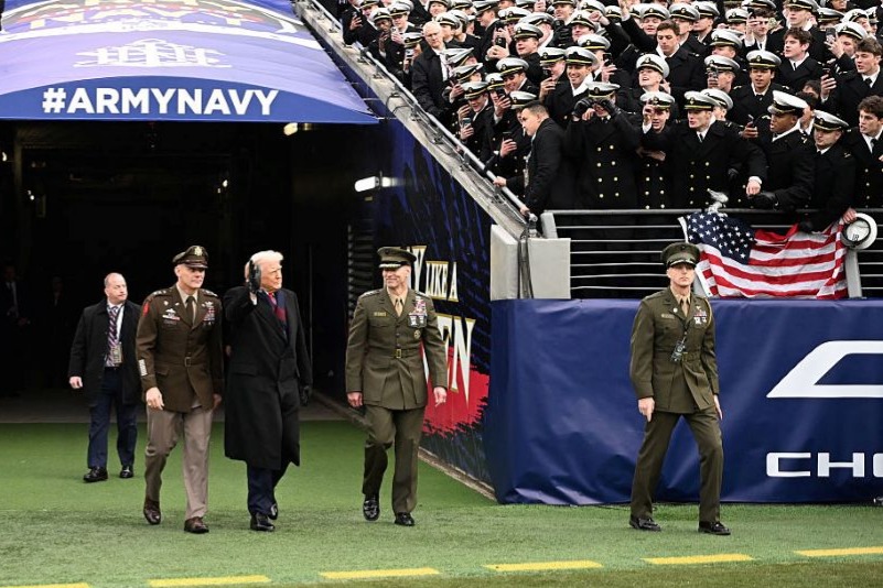 US President Donald Trump waves as he arrives on the field before the college football game between the US Army and Navy at the M&T Bank Stadium in Baltimore, Maryland, on December 13, 2025. (Photo by Alex WROBLEWSKI / AFP via Getty Images)