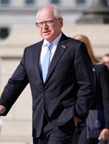 Minnesota Governor Tim Walz in a suit with a light blue tie.