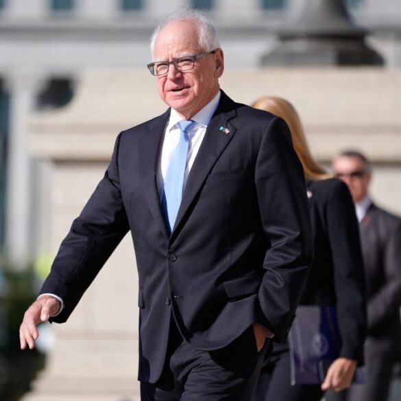 Minnesota Governor Tim Walz in a suit with a light blue tie.