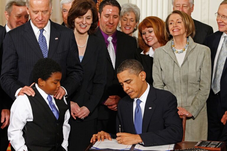 President Obama signing the Affordable Care Act into law.