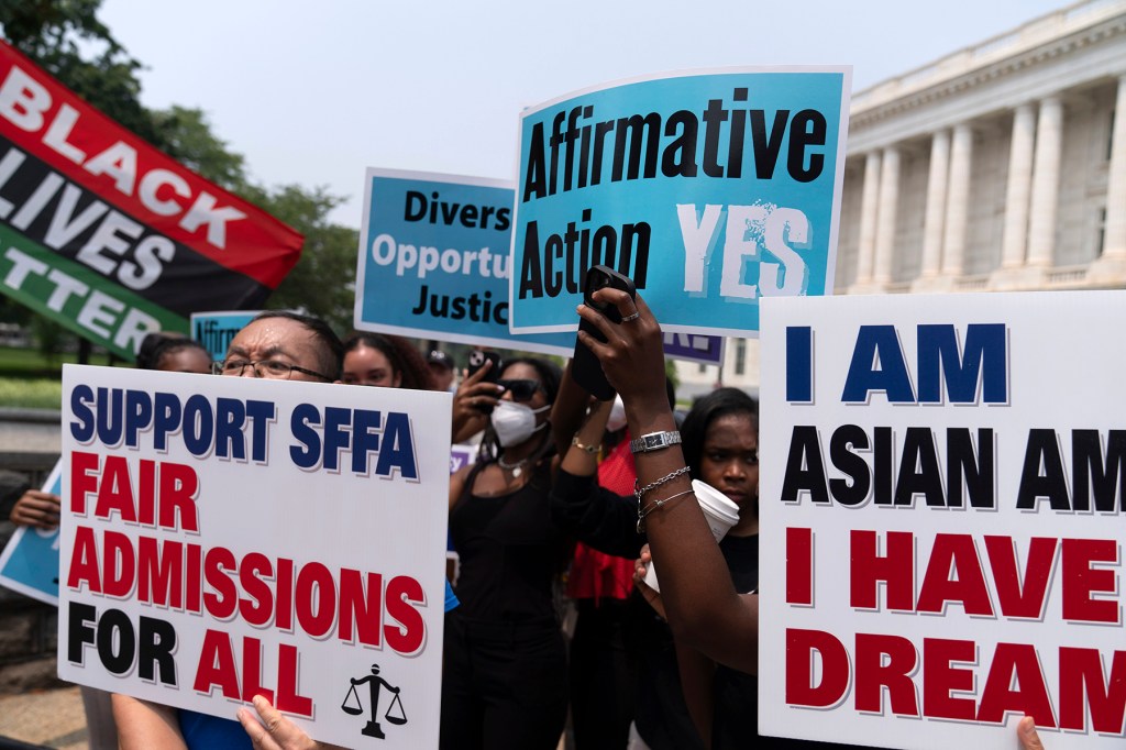 Protesters hold signs saying "Affirmative Action YES" and "Support SFFA Fair Admissions For All" outside a building.