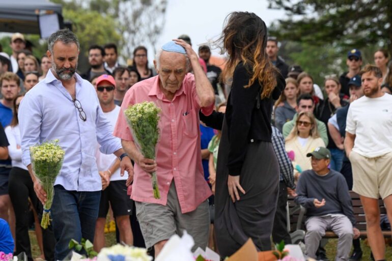 People lay flowers at Bondi Pavilion in tribute to victims of a terrorist attack.