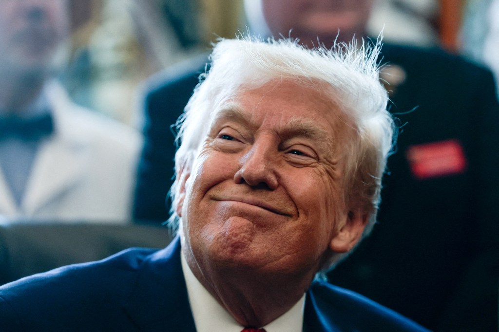 President Donald Trump sits in the Oval Office, to sign an executive order recommending loosening the federal regulations on marijuana, at the White House in Washington, D.C., U.S., December 18, 2025.