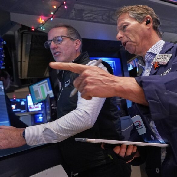 Specialist Glenn Carell and trader Robert Charmak work on the floor of the New York Stock Exchange.