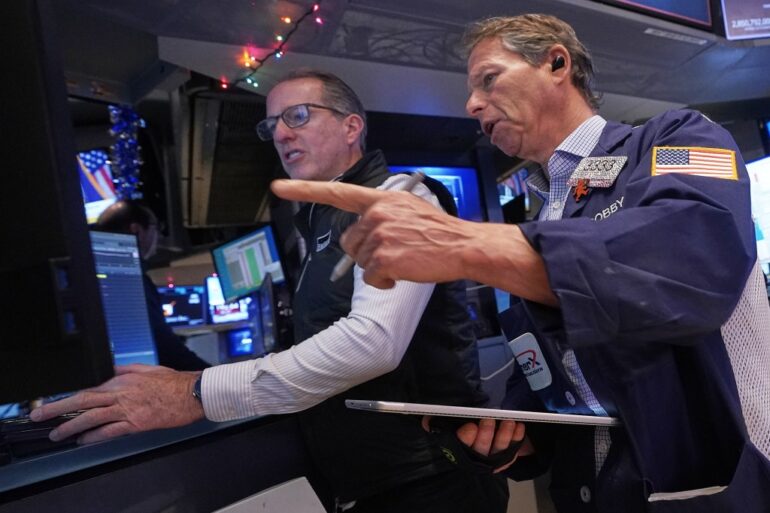 Specialist Glenn Carell and trader Robert Charmak work on the floor of the New York Stock Exchange.