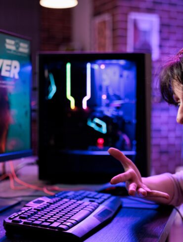 An angry woman wearing a headset and shouting after losing a game on her PC.