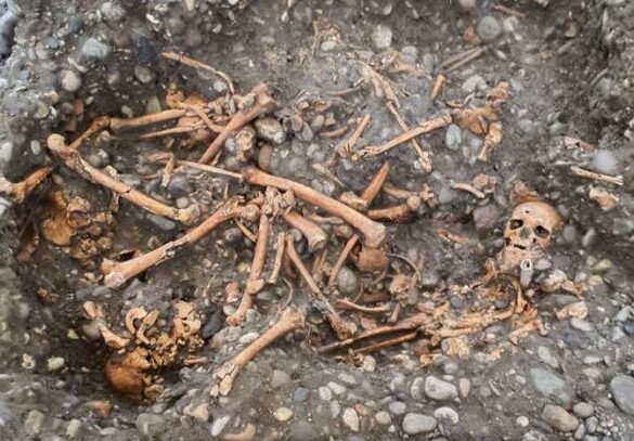 Multiple individuals buried in a pit by the gallows.