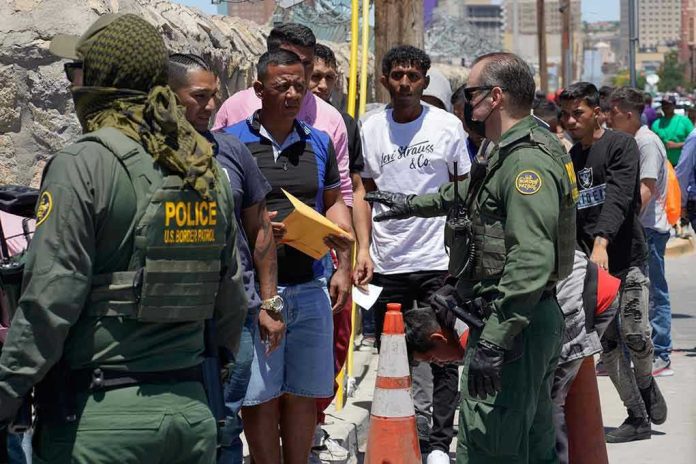 Border patrol agents inspecting group of individuals in line.